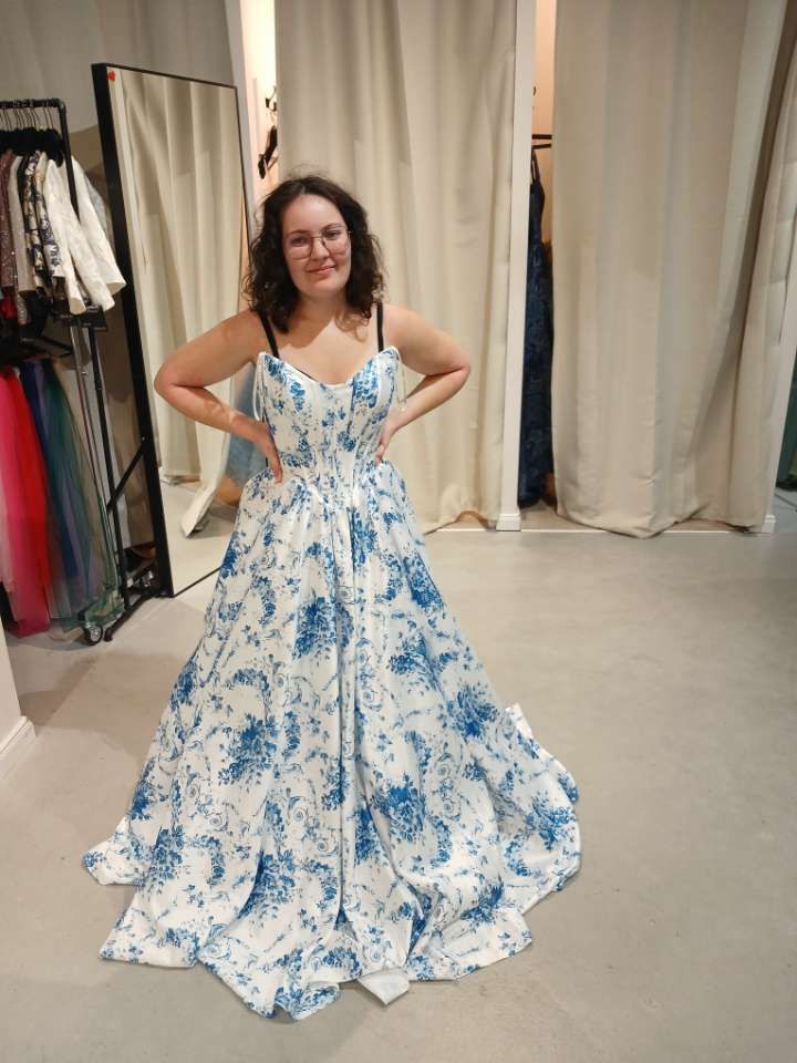 Ella trying on a blue and white floral ball gown